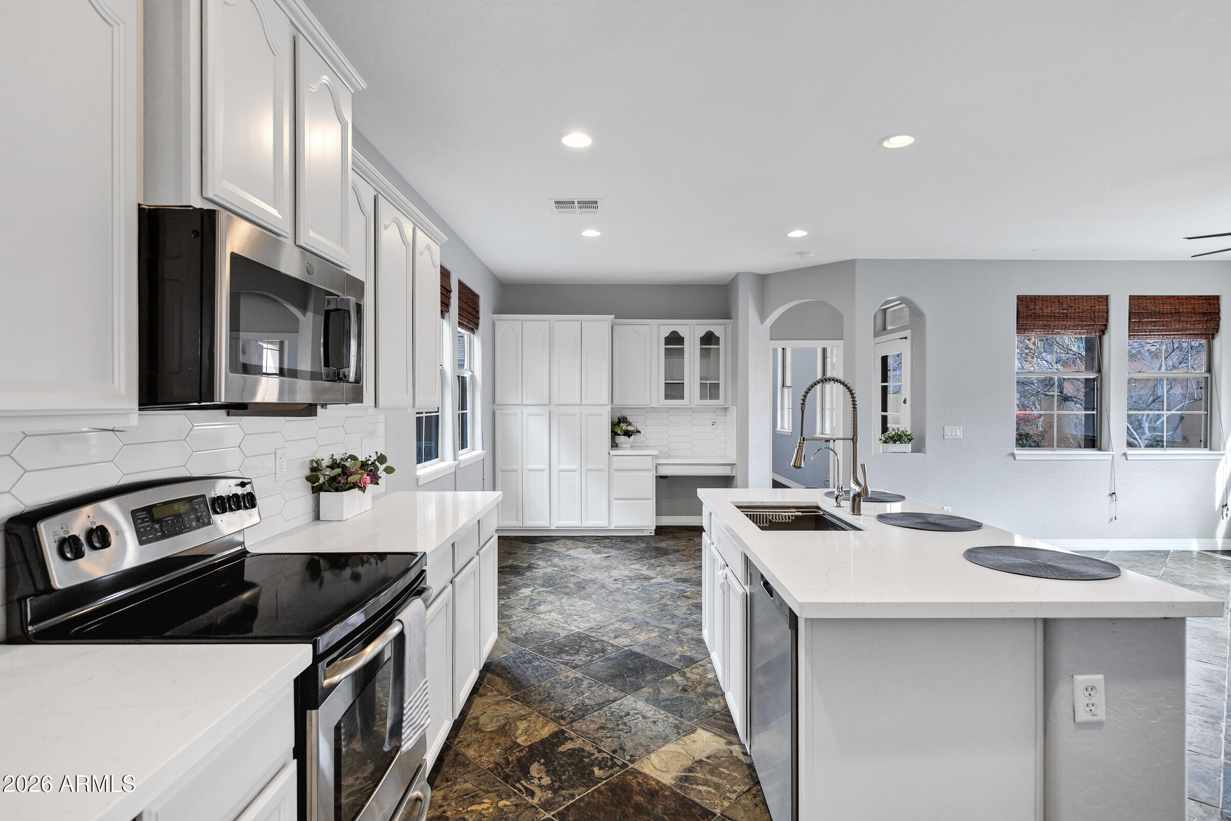 20982 West Edith Way Buckeye, AZ 85396 - Photo 11 of 57 a kitchen that has a sink a stove and chairs