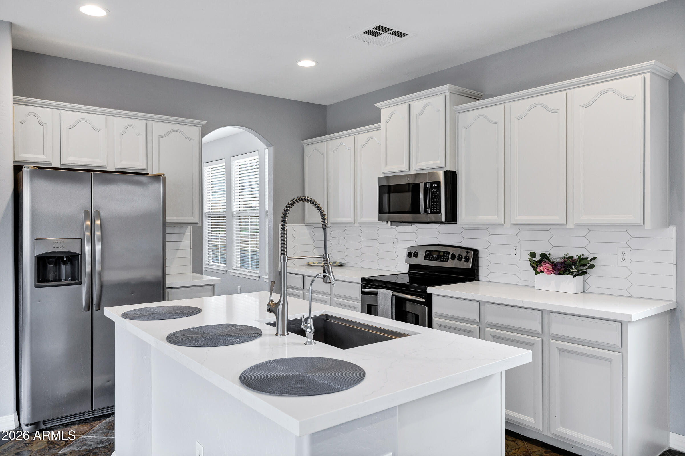 20982 West Edith Way Buckeye, AZ 85396 - Photo 13 of 57 a kitchen with stainless steel appliances granite countertop a sink stove refrigerator and microwave