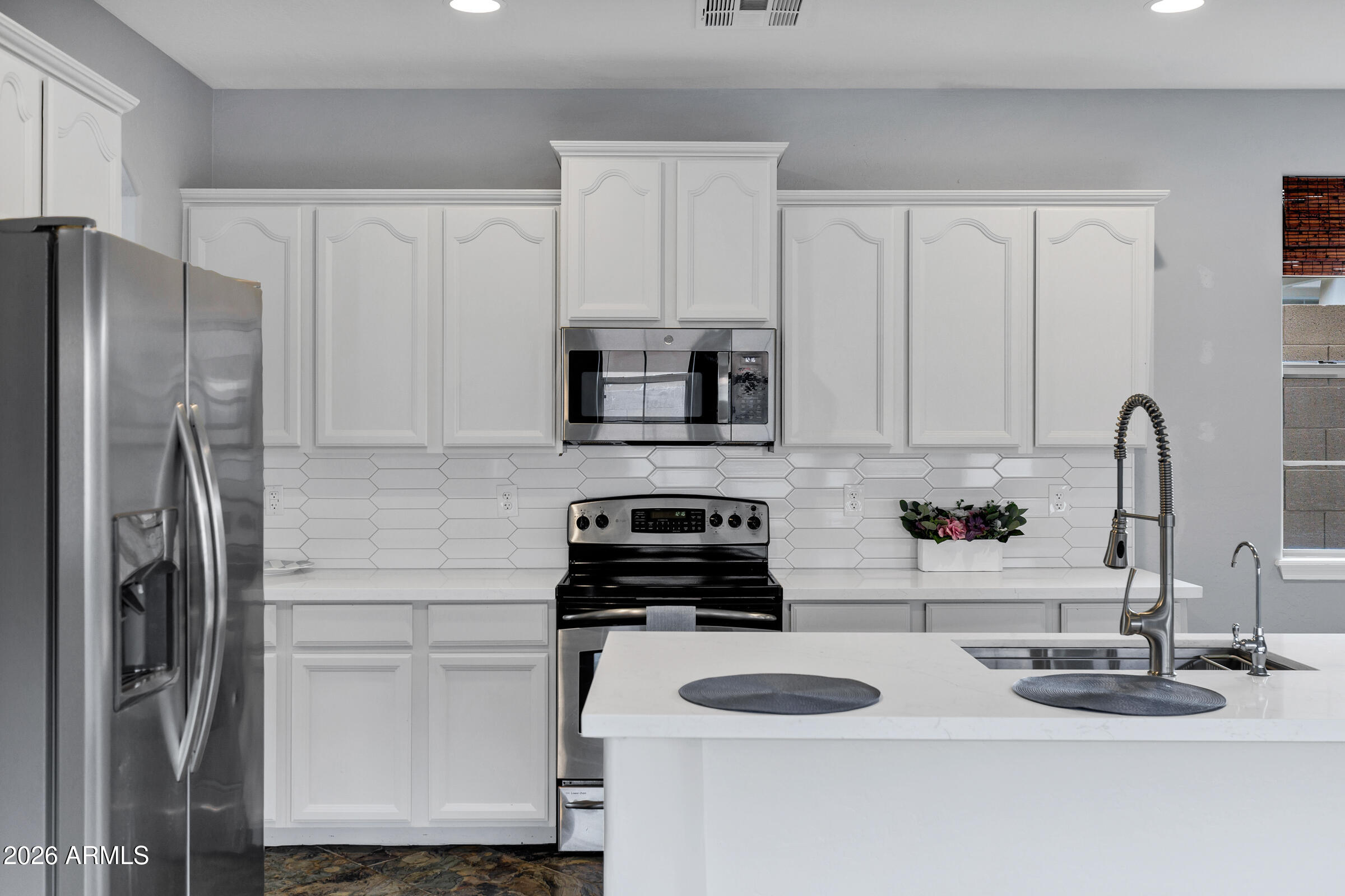 20982 West Edith Way Buckeye, AZ 85396 - Photo 14 of 57 a kitchen with a refrigerator and a stove