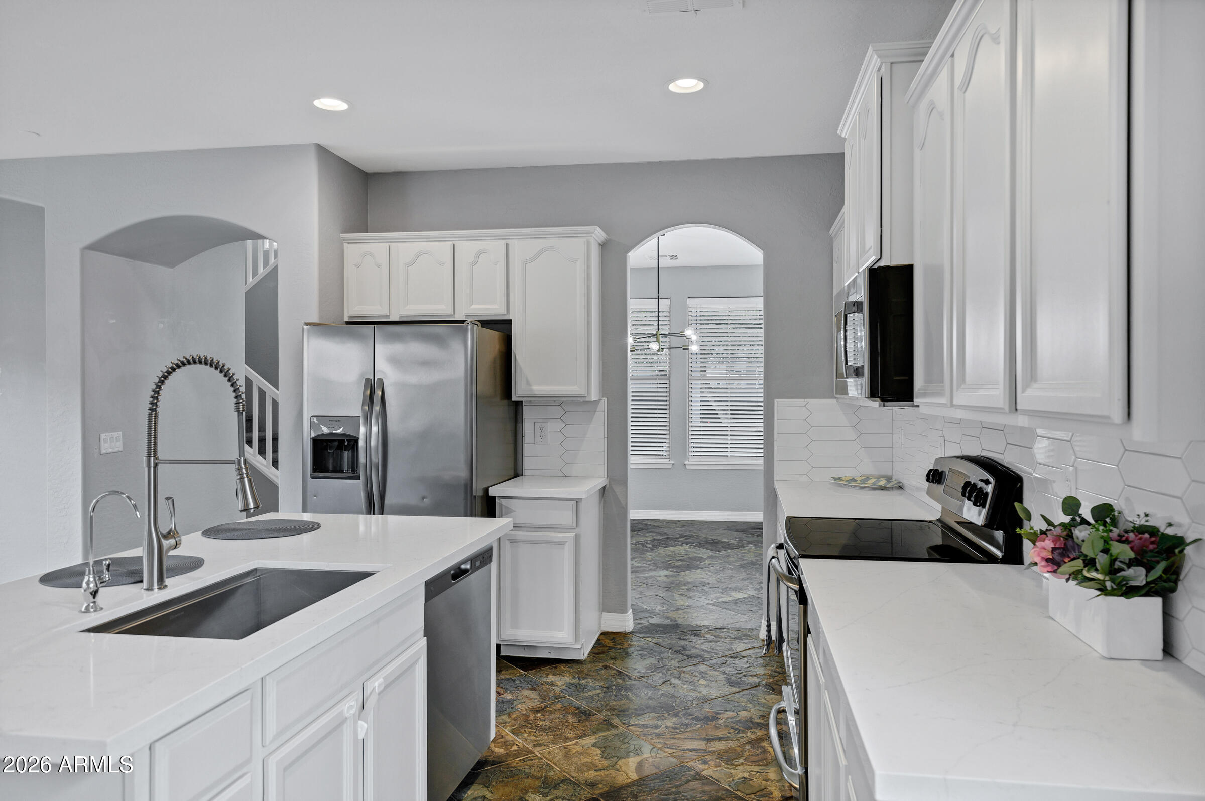 20982 West Edith Way Buckeye, AZ 85396 - Photo 15 of 57 a kitchen with stainless steel appliances a sink and a refrigerator