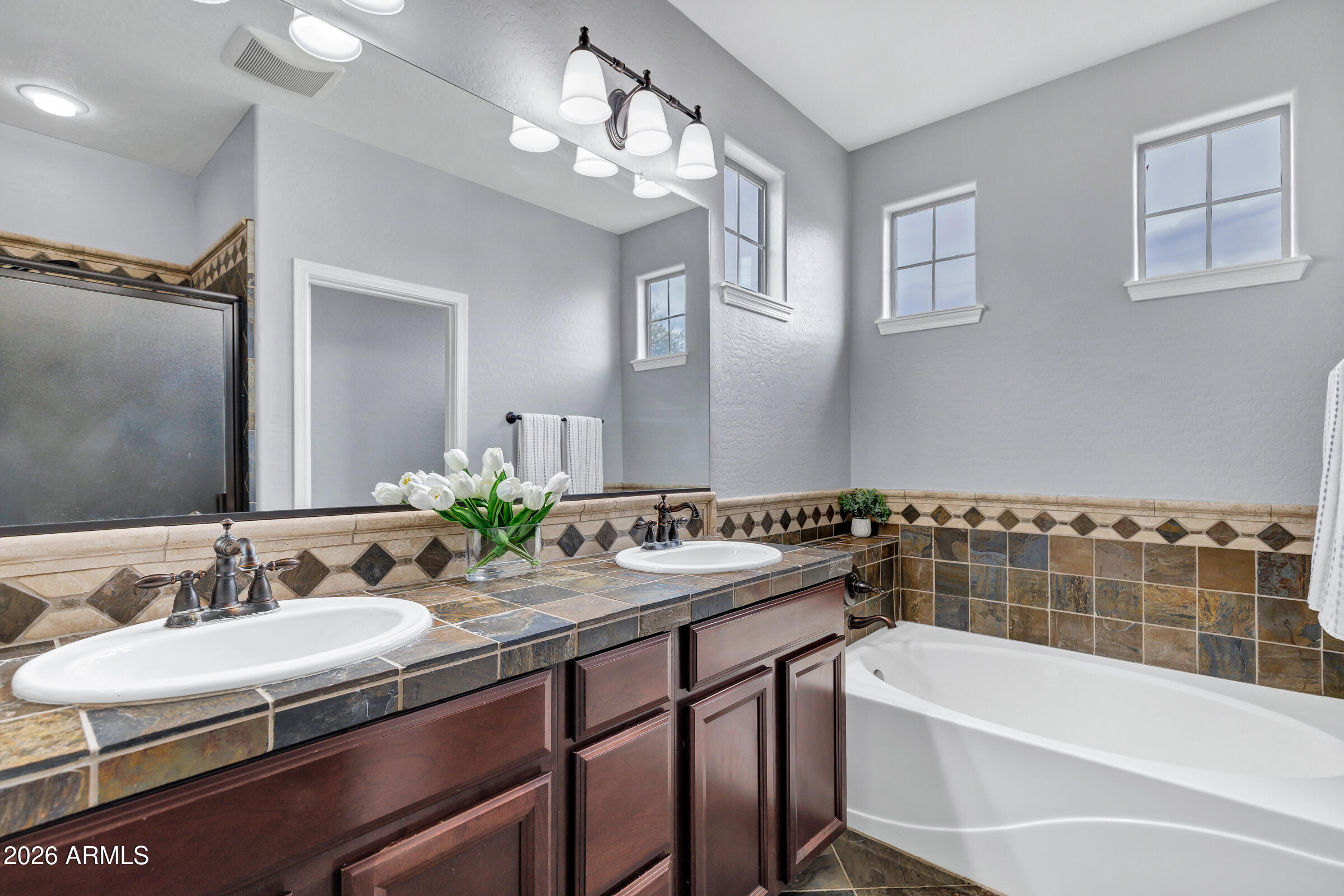 20982 West Edith Way Buckeye, AZ 85396 - Photo 35 of 57 a bathroom with a sink double vanity granite tub and a mirror