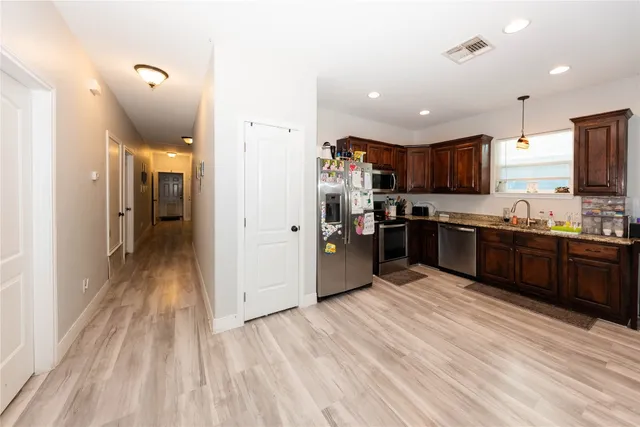 a large kitchen with kitchen island a sink stainless steel appliances and cabinets