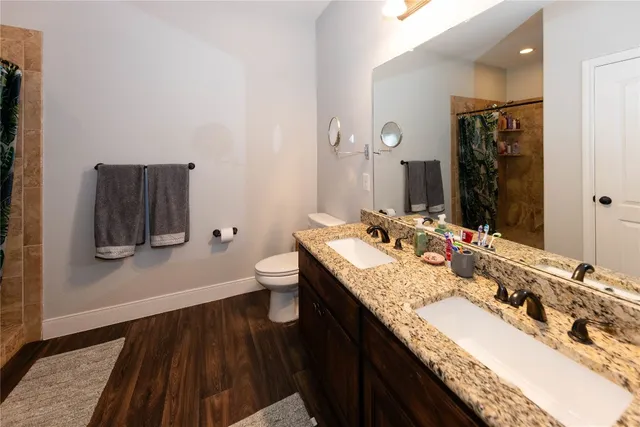 a bathroom with a granite countertop double vanity sink and two mirror