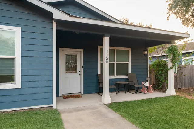 a view of a porch with chairs and floor to ceiling window