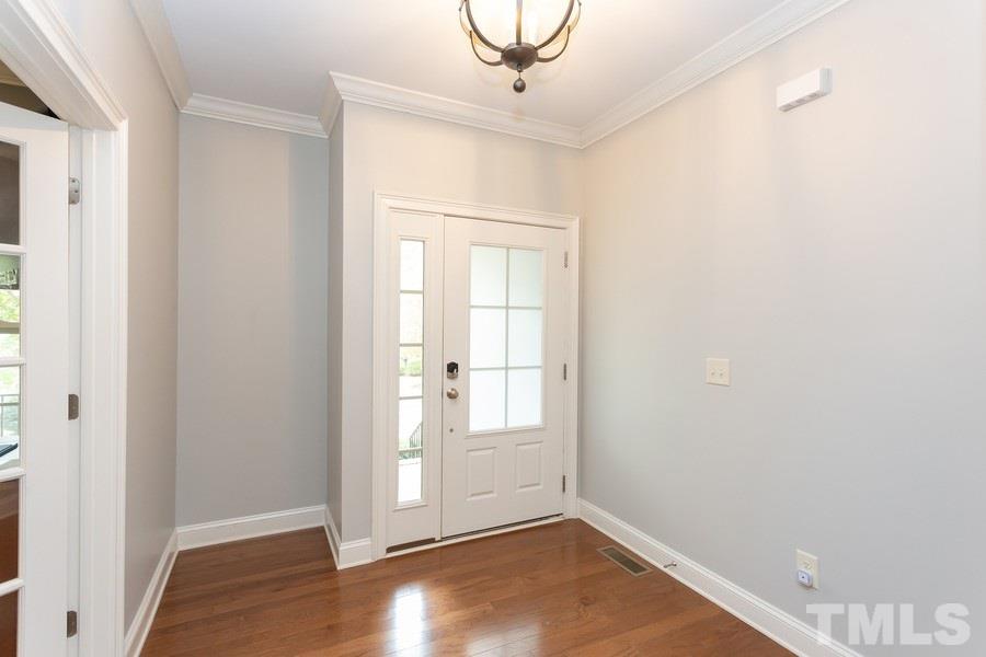 12816 Edsel Drive Raleigh, NC 27613 - Photo 2 of 25 an empty room with wooden floor cabinet and windows