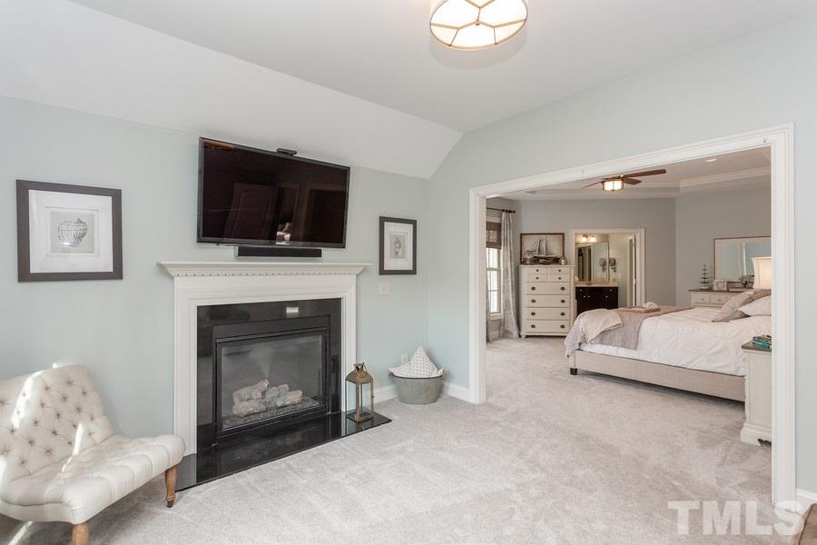 12816 Edsel Drive Raleigh, NC 27613 - Photo 14 of 25 a living room with furniture a flat screen tv and a fireplace