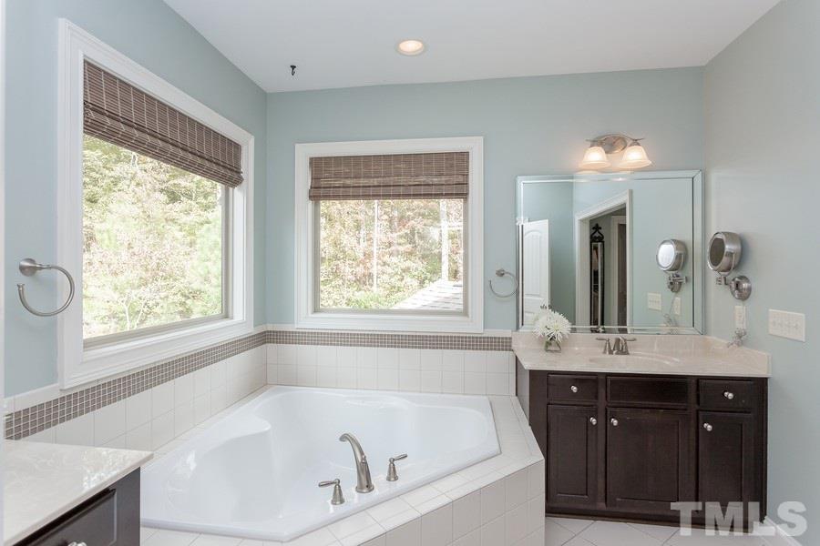 12816 Edsel Drive Raleigh, NC 27613 - Photo 16 of 25 a bathroom with a tub a sink and a window
