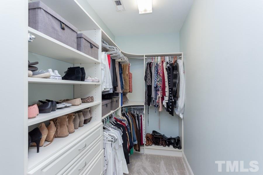 12816 Edsel Drive Raleigh, NC 27613 - Photo 17 of 25 a view of walk in closet with clothes and shoes