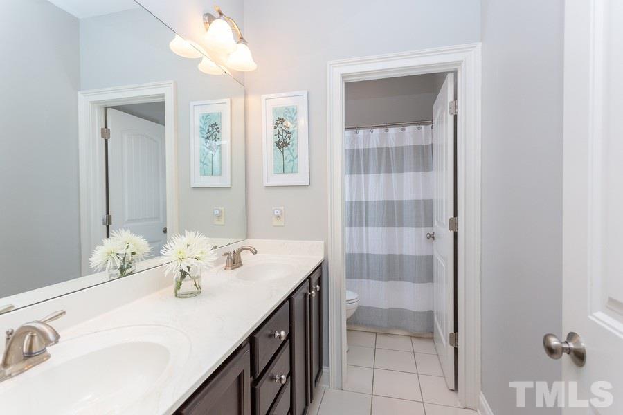 12816 Edsel Drive Raleigh, NC 27613 - Photo 20 of 25 a bathroom with a sink vanity and a mirror