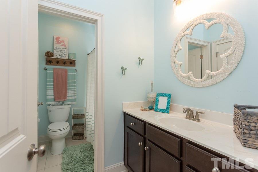 12816 Edsel Drive Raleigh, NC 27613 - Photo 22 of 25 a bathroom with a toilet a sink and mirror