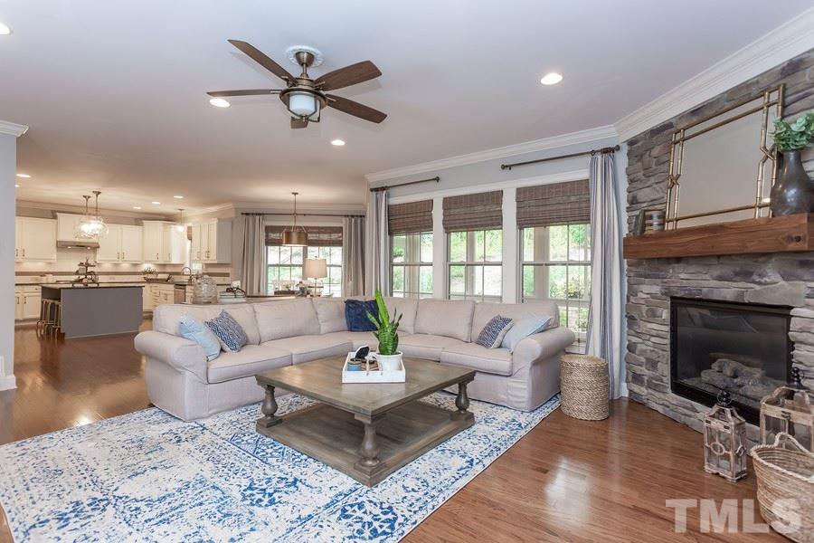 12816 Edsel Drive Raleigh, NC 27613 - Photo 5 of 25 a living room with furniture a fireplace and a ceiling fan