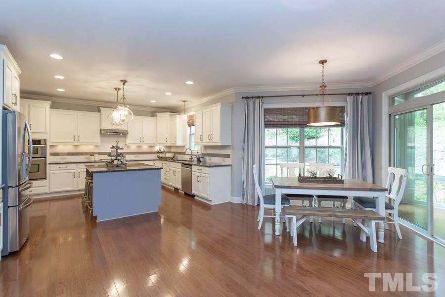 12816 Edsel Drive Raleigh, NC 27613 - Photo 7 of 25 a kitchen with a table chairs refrigerator and cabinets