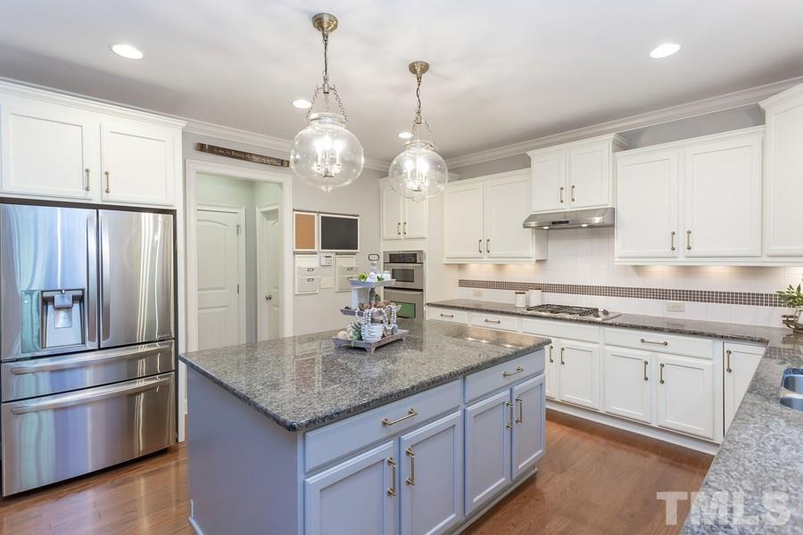 12816 Edsel Drive Raleigh, NC 27613 - Photo 8 of 25 a kitchen with stainless steel appliances granite countertop a sink refrigerator and cabinets