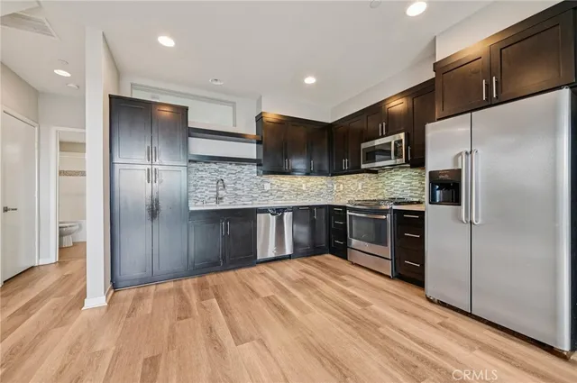 a kitchen with stainless steel appliances granite countertop a stove a refrigerator and a sink