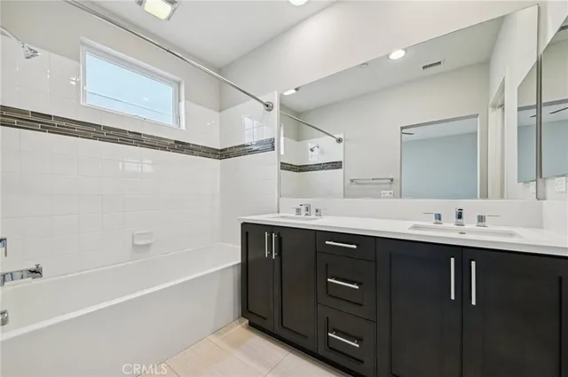 a bathroom with a double vanity sink mirror and shower