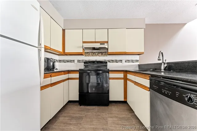 a kitchen with stainless steel appliances a refrigerator sink and cabinets