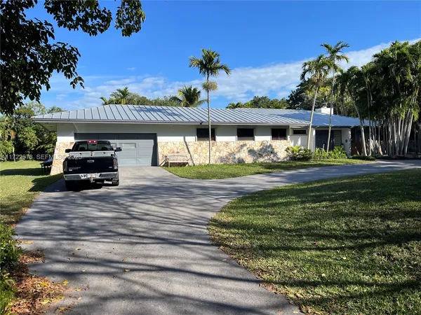 a car parked in front of a white house