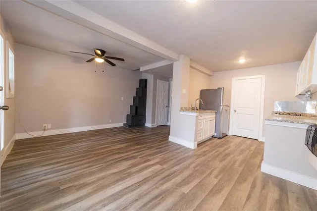 a view of a kitchen with wooden floor and electronic appliances