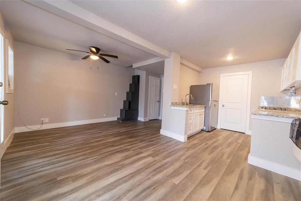 4838 Williams Spring Road Fort Worth, TX 76135 - Photo 13 of 17 a view of a kitchen with wooden floor and electronic appliances