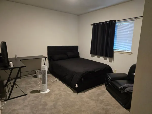 a bedroom with a bed and a chair