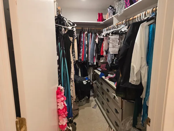 a view of walk in closet with clothes