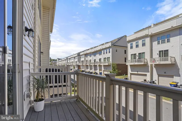 a kitchen with stainless steel appliances granite countertop a stove a microwave a sink a refrigerator white cabinets and a wooden floor