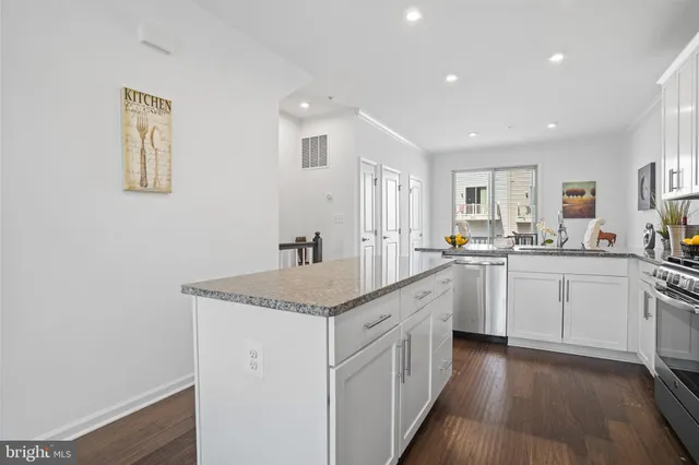 a kitchen with stainless steel appliances granite countertop a refrigerator a sink a stove a microwave and island