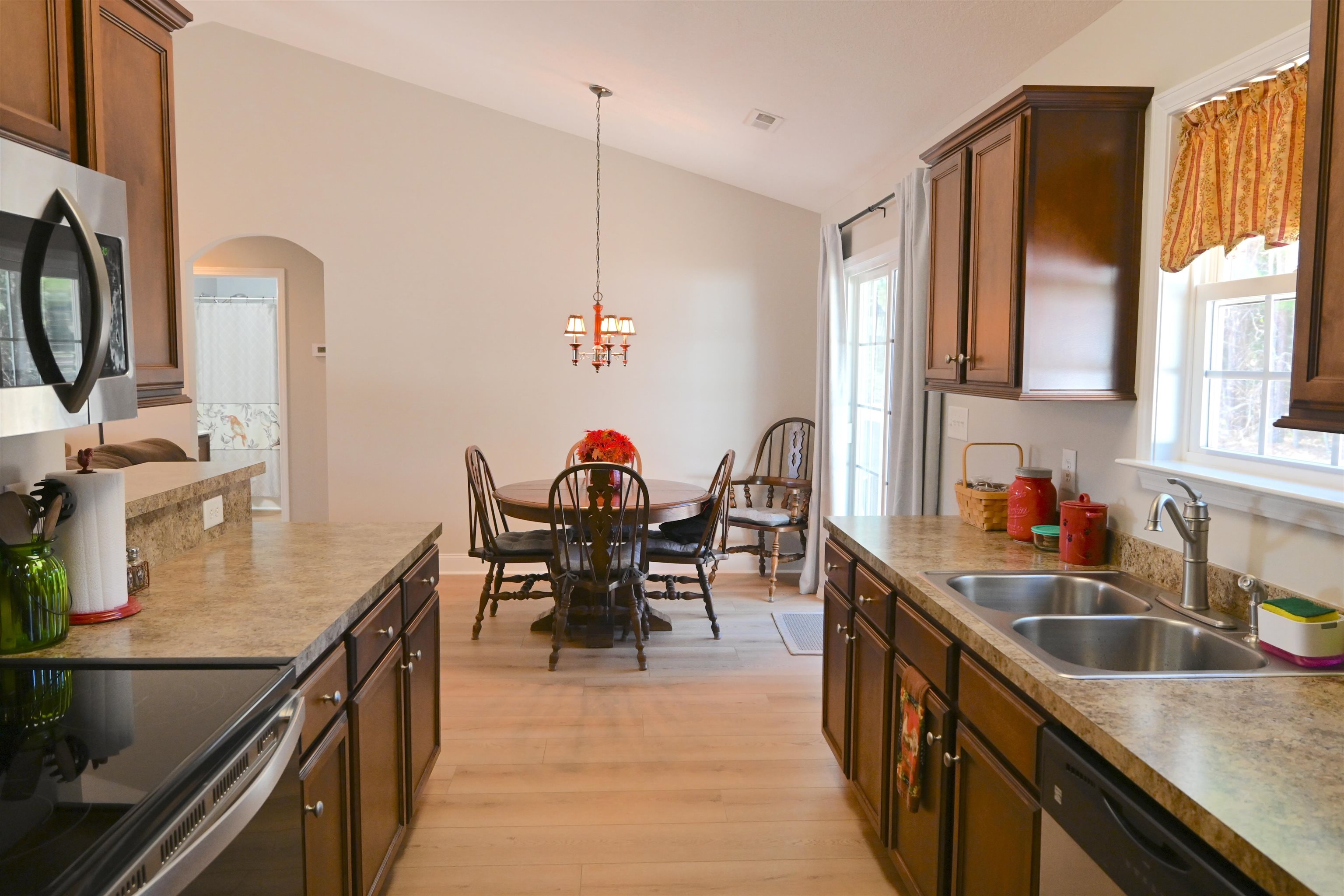 233 Macarthur Drive Conway, SC 29527 - Photo 11 of 21 Kitchen with decorative light fixtures, light wood-style flooring, stainless steel appliances, arched walkways, and lofted ceiling
