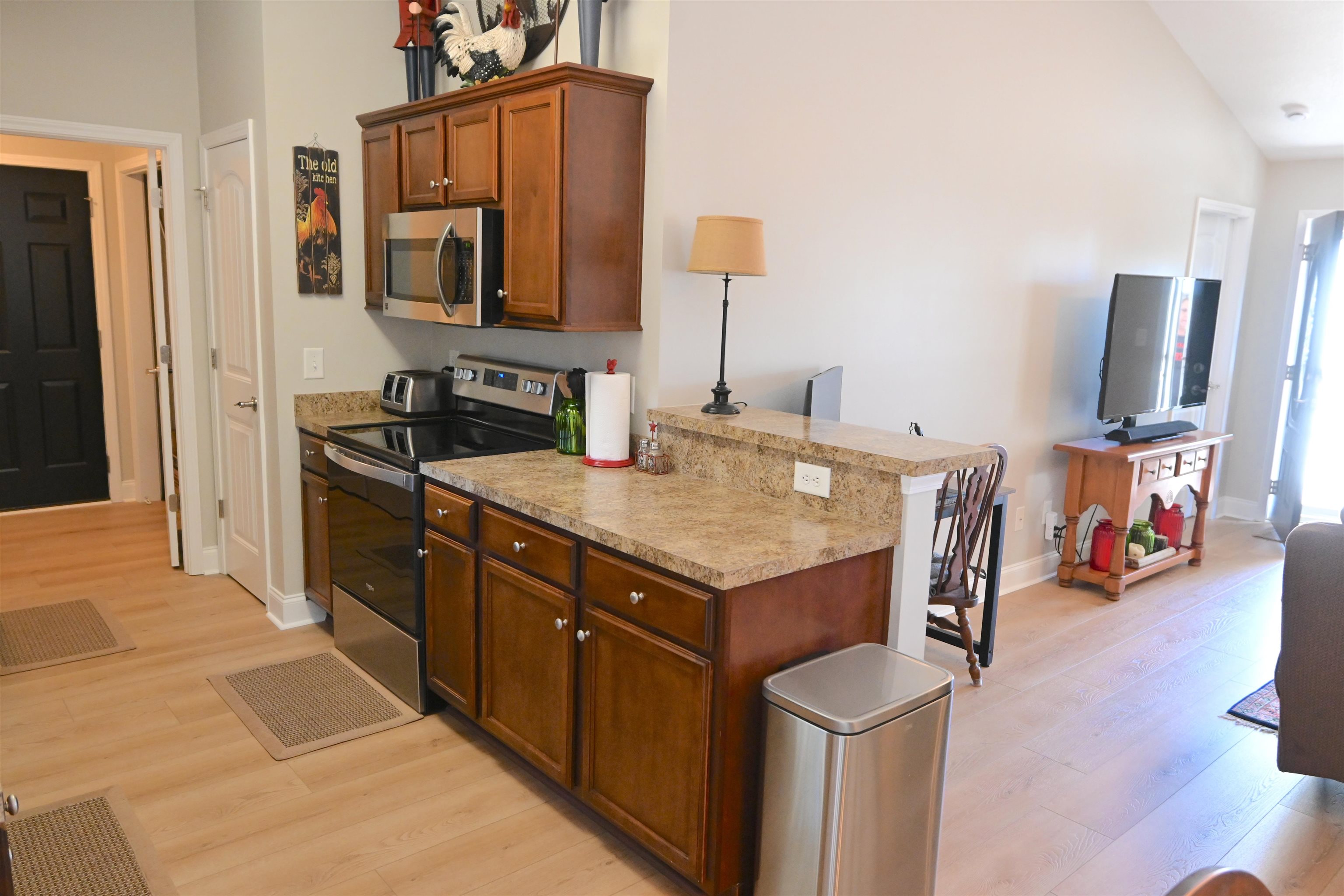 233 Macarthur Drive Conway, SC 29527 - Photo 10 of 21 Kitchen with stainless steel appliances, light wood-style flooring, light countertops, brown cabinetry, and high vaulted ceiling