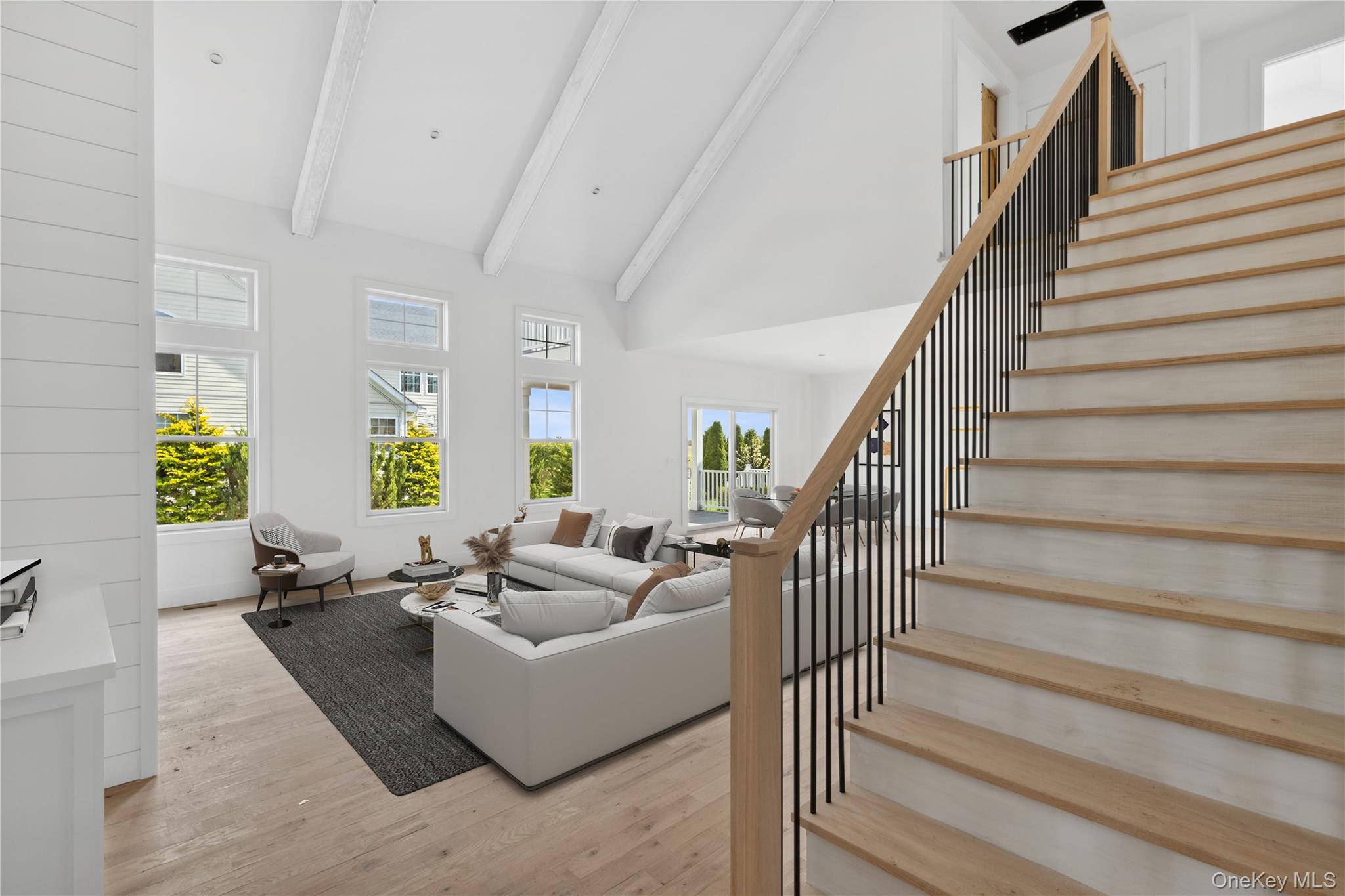 74 Tyler Drive Riverhead, NY 11901 - Photo 2 of 23 Living room featuring high vaulted ceiling, stairs, beam ceiling, and light wood-style floors