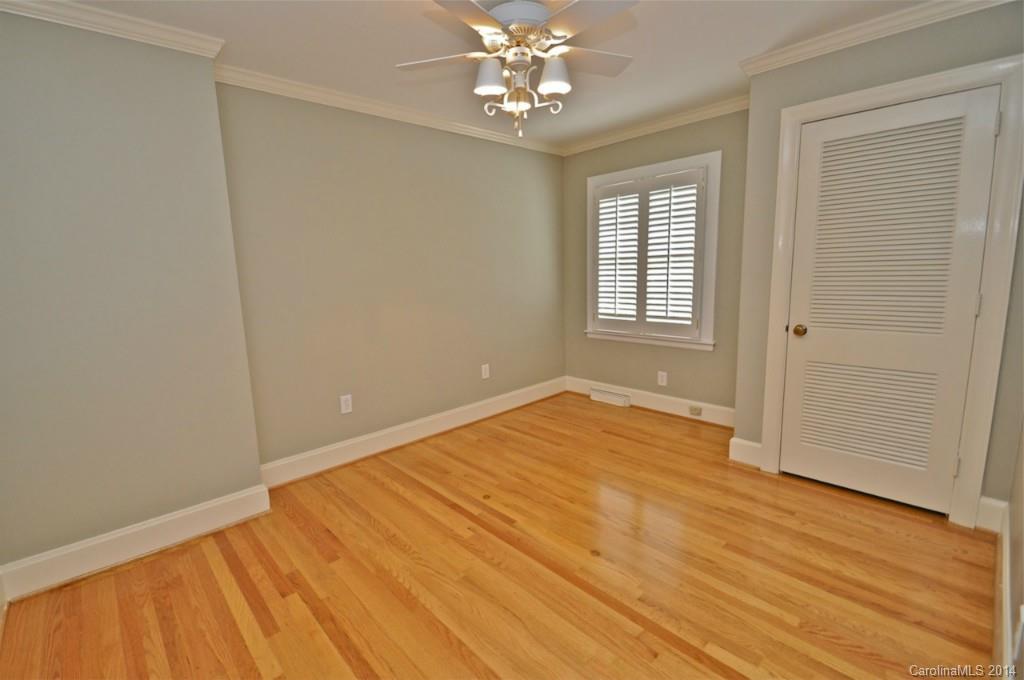 1931 Providence Road Charlotte, NC 28211 - Photo 18 of 22 an empty room with wooden floor chandelier fan and windows