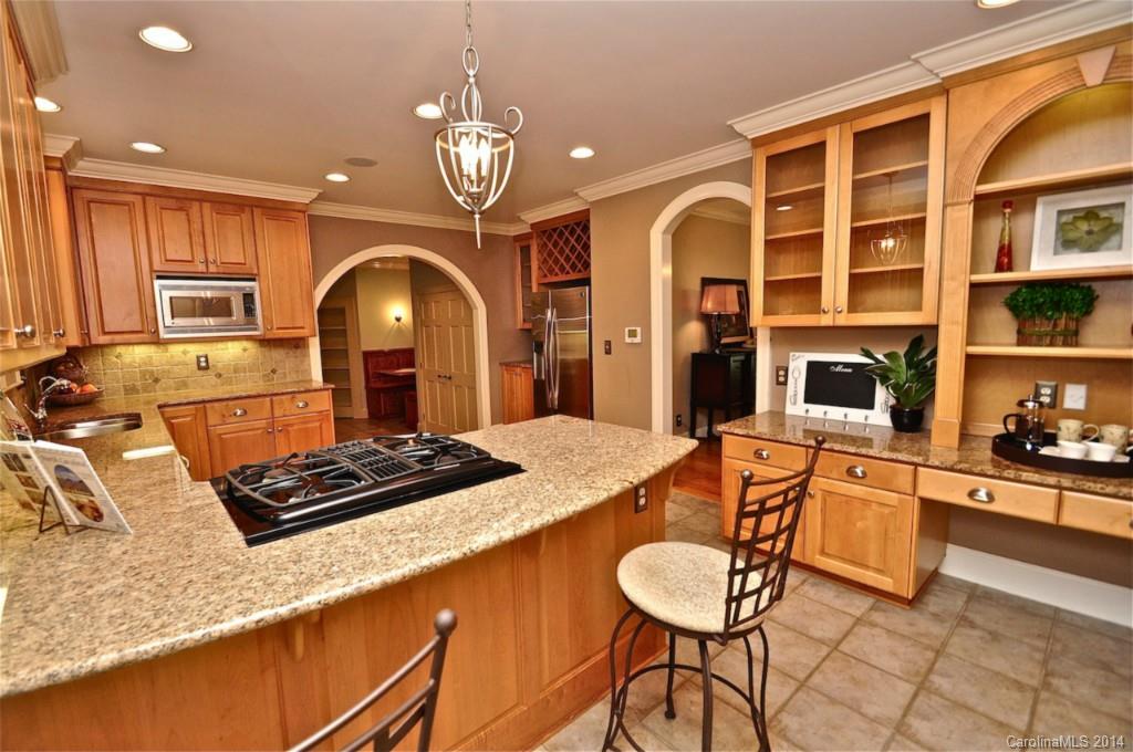 1931 Providence Road Charlotte, NC 28211 - Photo 9 of 22 a kitchen with stainless steel appliances granite countertop a stove a refrigerator a kitchen island a dining table and chairs with wooden floor