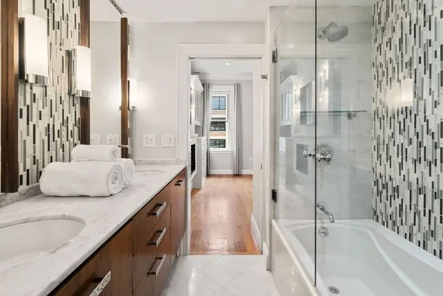 a bathroom with a granite countertop sink and a bathtub