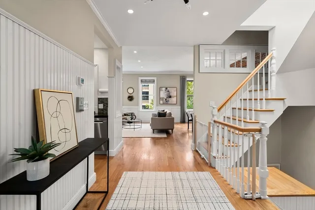 a view of a hallway with wooden floor and staircase