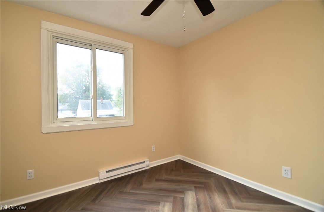 13300 Rockside Road Garfield Heights, OH 44125 - Photo 21 of 32 Spare room with ceiling fan, dark parquet floors, and baseboard heating
