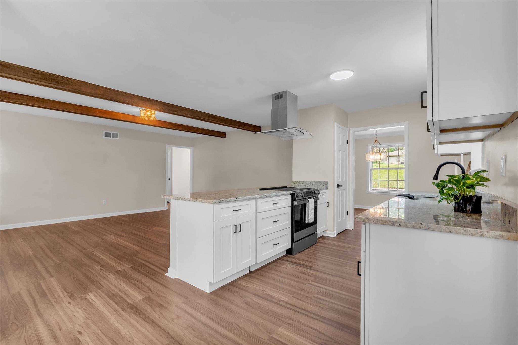 5509 Rappahannock Drive Memphis, TN 38134 - Photo 10 of 27 Kitchen featuring light stone counters, island range hood, white cabinets, electric stove, and a peninsula