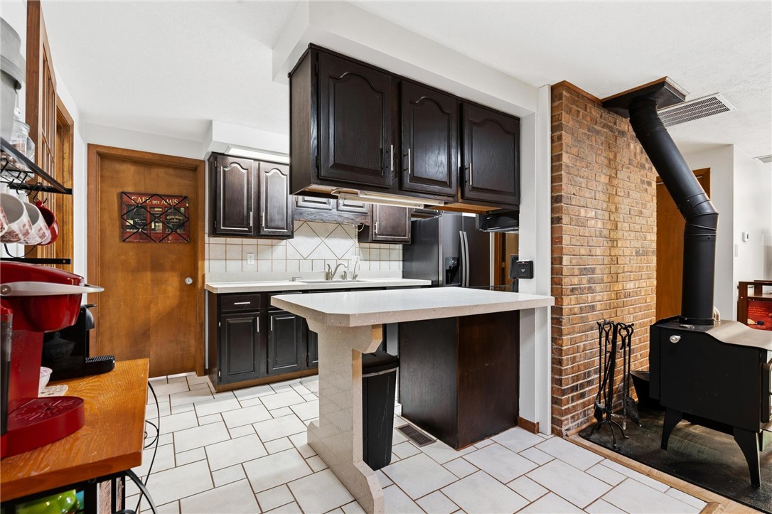 1940 Armstrong Road Fairborn, OH 45324 - Photo 23 of 48 This cozy kitchen features a practical layout with durable tile flooring and a rustic brick accent wall.