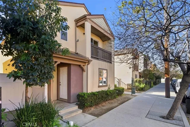 a front view of a house with trees and plants