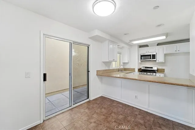 a kitchen with granite countertop a refrigerator and a sink