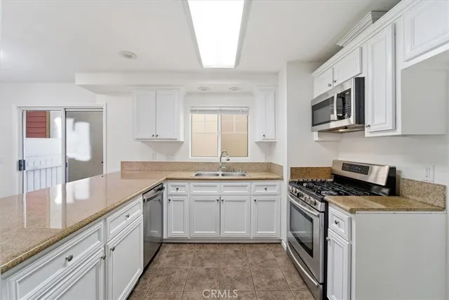 a kitchen with stainless steel appliances granite countertop a sink stove and microwave