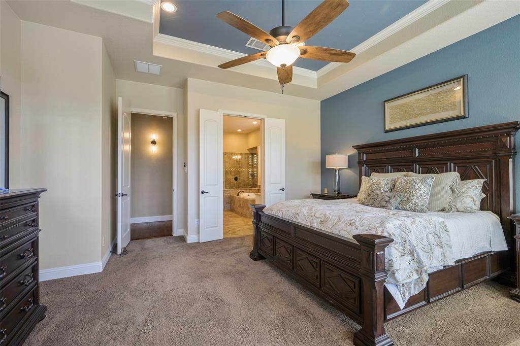 1220 Packsaddle Trail Prosper, TX 75078 - Photo 17 of 33 a spacious bedroom with a bed and a chandelier