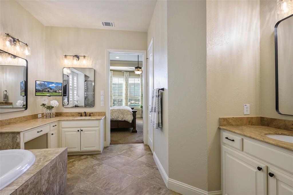 1220 Packsaddle Trail Prosper, TX 75078 - Photo 19 of 33 a spacious bathroom with a granite countertop sink a mirror and a bathtub