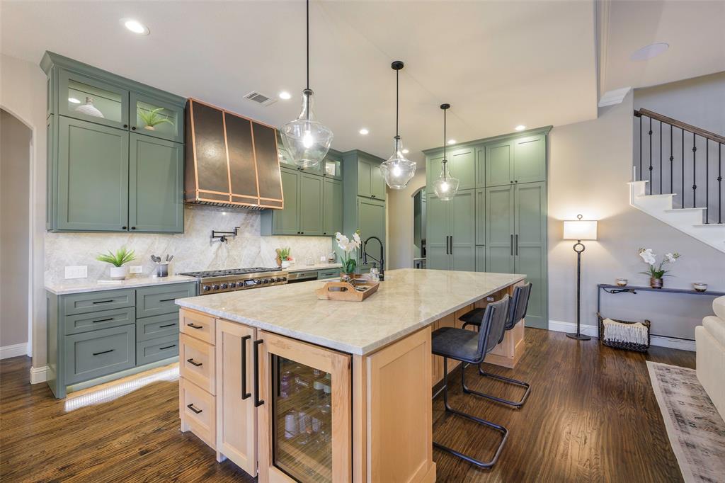 1220 Packsaddle Trail Prosper, TX 75078 - Photo 6 of 33 a kitchen that has a lot of cabinets in it and wooden floors