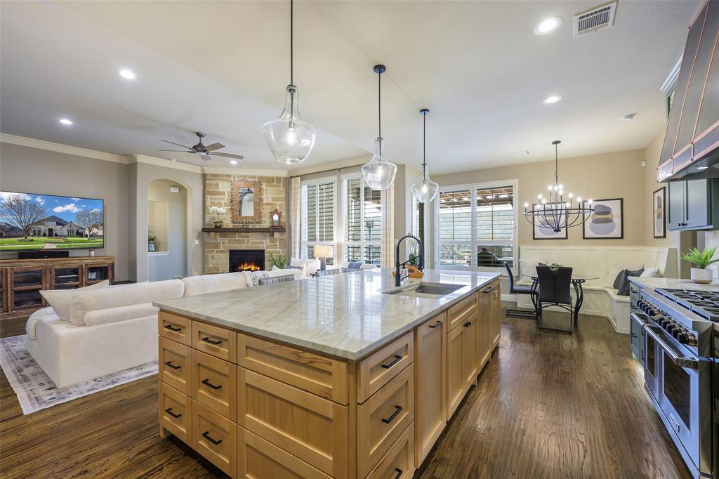 1220 Packsaddle Trail Prosper, TX 75078 - Photo 33 of 33 a large kitchen with kitchen island a stove a sink a dining table and chairs