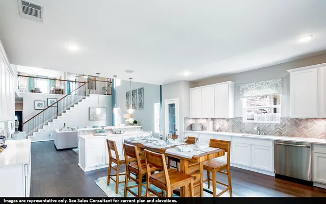 a kitchen with a dining table chairs and white cabinets
