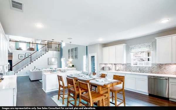 a kitchen with a dining table chairs and white cabinets