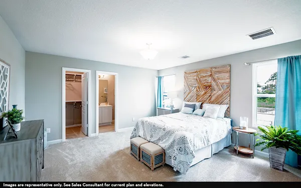 a bedroom with a large bed and a potted plant