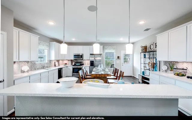 a kitchen with stainless steel appliances kitchen island granite countertop a sink a stove and a refrigerator