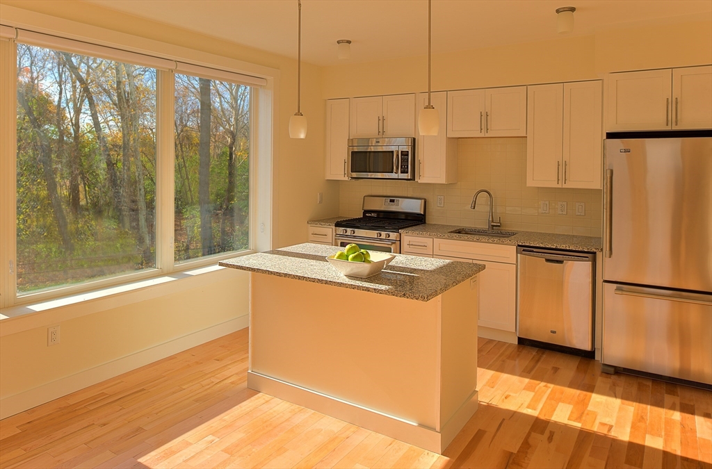 a kitchen with stainless steel appliances a refrigerator sink and microwave
