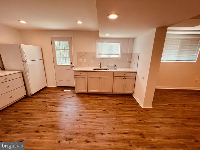 a kitchen with stainless steel appliances granite countertop a refrigerator a stove and a wooden floors